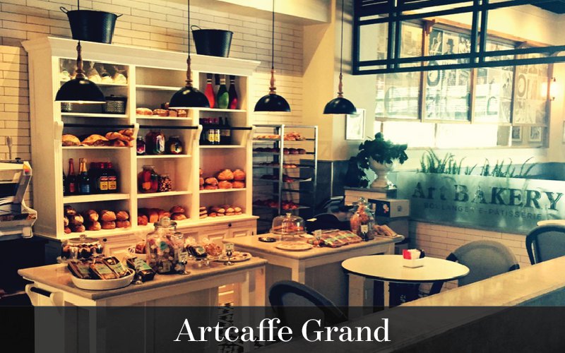 Nice image of Artcafee Grand with shelves of pastries and coffee beans 