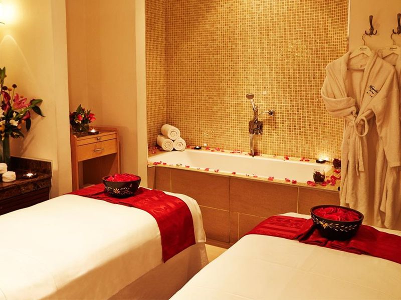 couples massage room with rose petals and bathtub