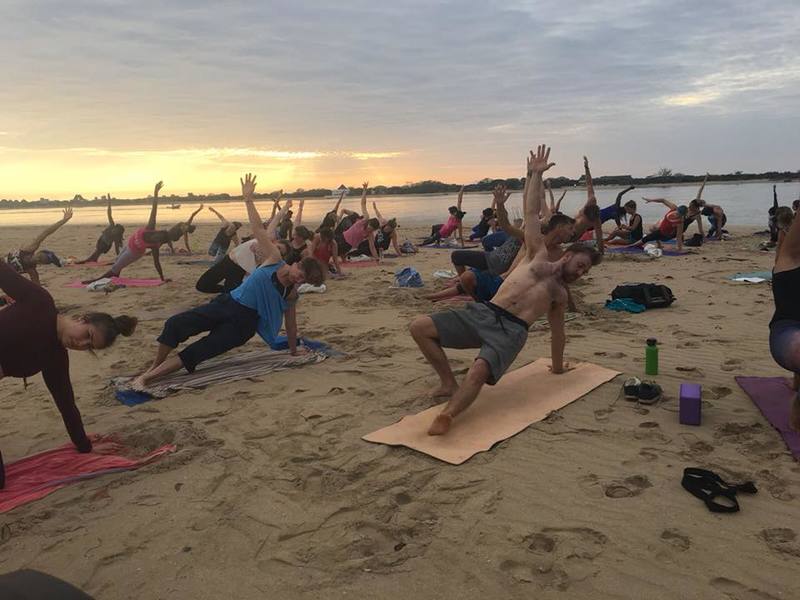 People doing Yoga on the beach