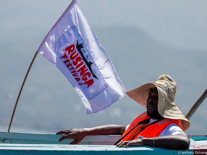 Man chilling on a canoe with the Rusinga Festival banner