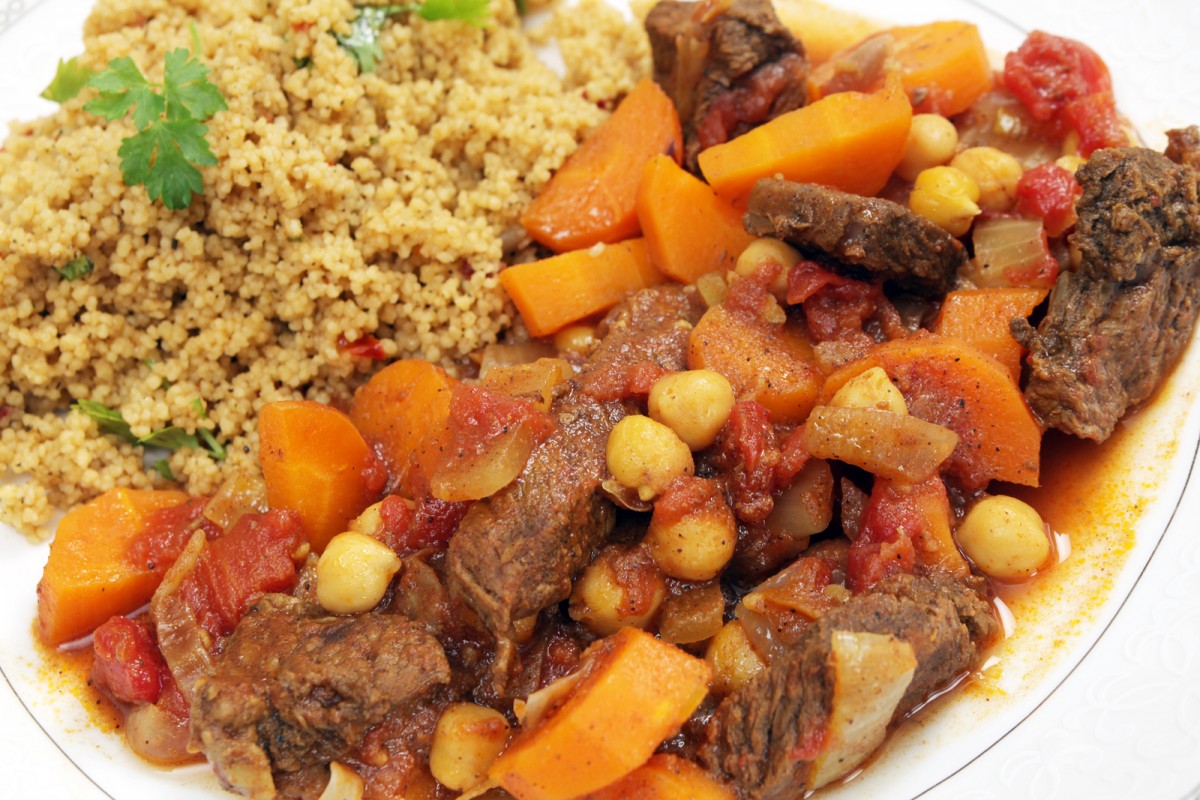 Plate of traditional Moroccan beef tagine with couscous, garnish